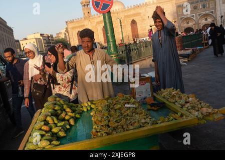 Cairo, Egitto. 2 luglio 2024 Un titolare del mercato che vende frutta di cactus di fico d'India nell'affollato quartiere islamico del Cairo accanto alla Moschea al Ahzar, E. Foto Stock