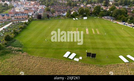 Vista aerea di una partita di cricket giocata su un campo ai margini della storica città mercato di Wimborne Minister nel Dorset, Inghilterra, Regno Unito Foto Stock