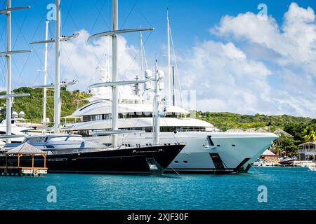 Diversi mega yacht e superyacht bellissimi e immacolati al molo di English Harbour, una famosa isola caraibica di Antigua conosciuta per la stagione degli yacht e le regate Foto Stock