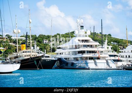 Diversi mega yacht e superyacht bellissimi e immacolati al molo di English Harbour, una famosa isola caraibica di Antigua conosciuta per la stagione degli yacht e le regate Foto Stock