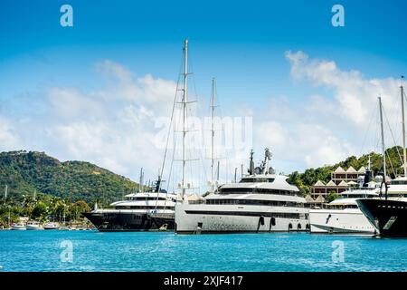 Diversi mega yacht e superyacht bellissimi e immacolati al molo di English Harbour, una famosa isola caraibica di Antigua conosciuta per la stagione degli yacht e le regate Foto Stock