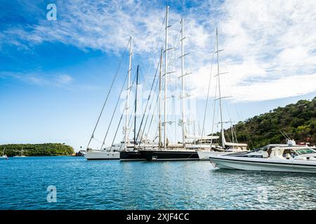 Diversi mega yacht e superyacht bellissimi e immacolati al molo di English Harbour, una famosa isola caraibica di Antigua conosciuta per la stagione degli yacht e le regate Foto Stock