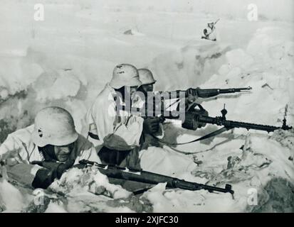 Una fotografia mostra i soldati tedeschi in una trincea innevata, che si preparano a difendersi dall'avanzata delle forze sovietiche. Scattata durante l'operazione Barbarossa nel 1941, questa immagine evidenzia le dure condizioni e gli intensi combattimenti a terra affrontati dalle truppe tedesche mentre avanzavano sul fronte orientale durante la seconda guerra mondiale. Foto Stock