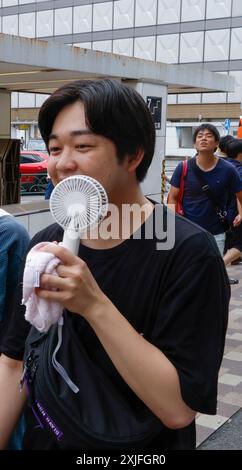 SCALDARE LE RAGAZZE DI TOKYO USANDO I VENTILATORI PORTATILI Foto Stock