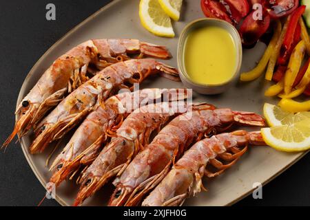 Gamberi fritti sul piatto con verdure fresche e fetta di limone. Sfondo di pesce. Foto Stock