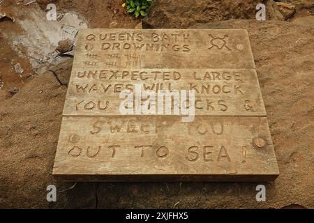 Princeville, Kauai, Hawaii / Stati Uniti d'America - 8 giugno 2018: Un cartello in legno inciso avverte di condizioni potenzialmente pericolose e di annegamento nella piscina delle maree di Queen's Bath. Foto Stock