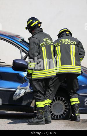 Vicenza, vi, Italia - 23 maggio 2024: Due vigili del fuoco italiani usano lo squalo della vita per aprire la porta di un'auto distrutta Foto Stock