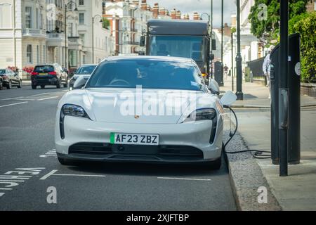 LONDRA - 16 LUGLIO 2024: Auto elettrica Porsche in carica nella zona di Chelsea Kensington Street nel sud-ovest di Londra Foto Stock