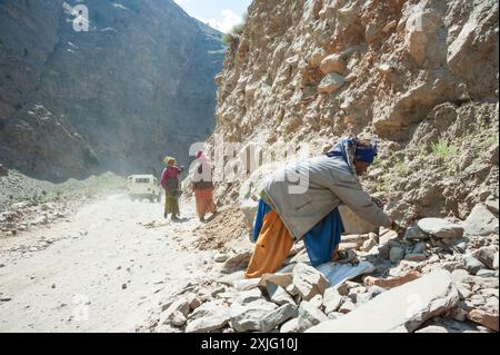 Donne che lavorano duramente per la costruzione di una strada sulle montagne dell'Himachal Pradesh in estate, in India Foto Stock