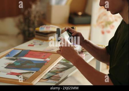 Designer che scatta foto di collage su smartphone Foto Stock