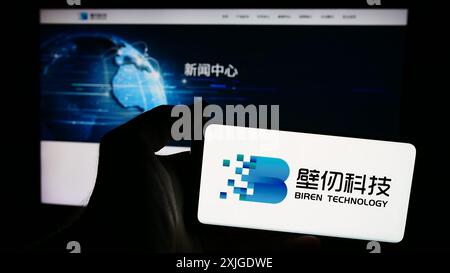 Persona che detiene uno smartphone con il logo dell'azienda cinese Shanghai Biren Technology Co. Ltd. Davanti al sito Web. Mettere a fuoco il display del telefono. Foto Stock