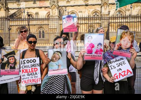 Londra, 18 luglio 2024. Manifestanti con immagini di bambini uccisi nel conflitto. Migliaia di attivisti filo-palestinesi formano una catena umana attorno al Parlamento questa sera a Westminster, chiedendo al nuovo governo di fermare le vendite di armi al governo israeliano. Diversi parlamentari si uniscono alla protesta, mentre di fronte alla piazza del Parlamento, un gruppo israeliano protesta ancora Hamas e per il rilascio degli ostaggi palestinesi. Crediti: Imageplotter/Alamy Live News Foto Stock