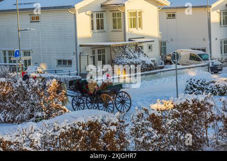 Slitta trainata da cavalli con Babbo Natale che porta con sé un buon sacco regalo di Natale in un villaggio invernale innevato. Svezia. Uppsala. Foto Stock