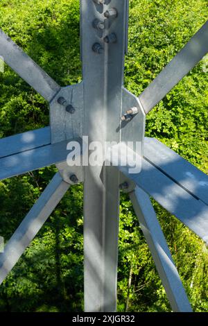 Collegamenti imbullonati di elementi in acciaio della torre di osservazione. Dettagli costruttivi in acciaio zincato su sfondo verde Foto Stock