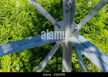 Collegamenti imbullonati di elementi in acciaio della torre di osservazione. Dettagli costruttivi in acciaio zincato su sfondo verde Foto Stock