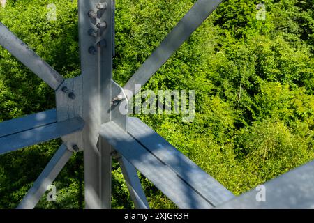 Collegamenti imbullonati di elementi in acciaio della torre di osservazione. Dettagli costruttivi in acciaio zincato su sfondo verde Foto Stock