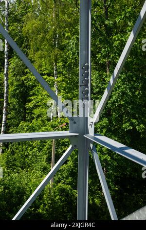 Collegamenti imbullonati di elementi in acciaio della torre di osservazione. Dettagli costruttivi in acciaio zincato su sfondo verde Foto Stock