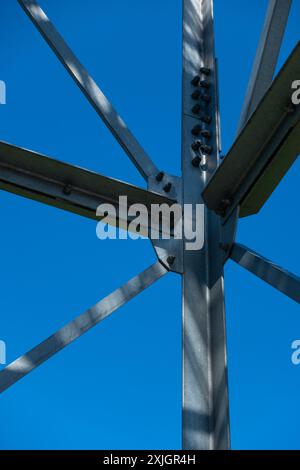 Collegamenti imbullonati di elementi in acciaio della torre di osservazione. Dettagli costruttivi in acciaio zincato su sfondo blu. Foto Stock