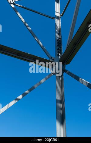 Collegamenti imbullonati di elementi in acciaio della torre di osservazione. Dettagli costruttivi in acciaio zincato su sfondo blu. Foto Stock