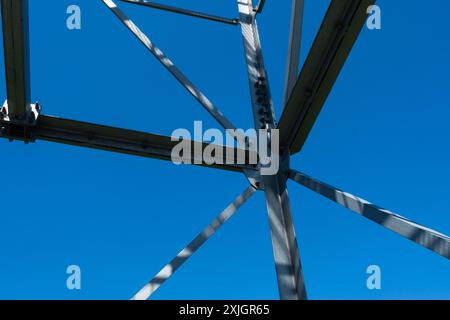 Collegamenti imbullonati di elementi in acciaio della torre di osservazione. Dettagli costruttivi in acciaio zincato su sfondo blu. Foto Stock