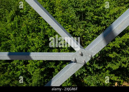 Collegamenti imbullonati di elementi in acciaio della torre di osservazione. Dettagli costruttivi in acciaio zincato su sfondo verde Foto Stock