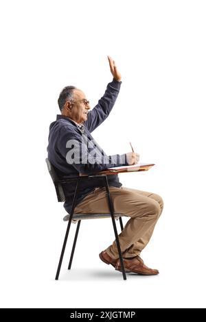 Uomo maturo seduto su una sedia scolastica e alzando la mano isolato su sfondo bianco Foto Stock