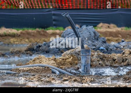 Tubi di rivestimento con anello di messa a terra in polietilene in fase di installazione in un nuovo campo di pozzi geotermici. Foto Stock