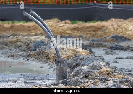 Tubi di rivestimento con anello di messa a terra in polietilene in fase di installazione in un nuovo campo di pozzi geotermici. Foto Stock