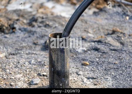 Tubi di rivestimento con anello di messa a terra in polietilene in fase di installazione in un nuovo campo di pozzi geotermici. Foto Stock