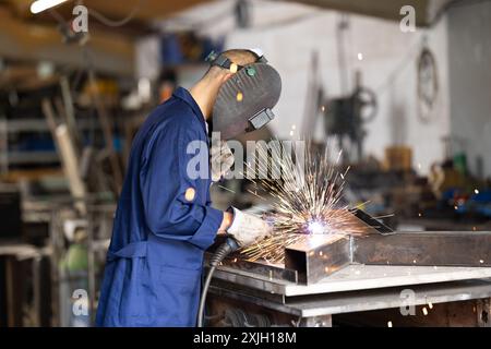 Durante la fabbricazione del prodotto, il dipendente MAN lavora con una saldatrice Foto Stock