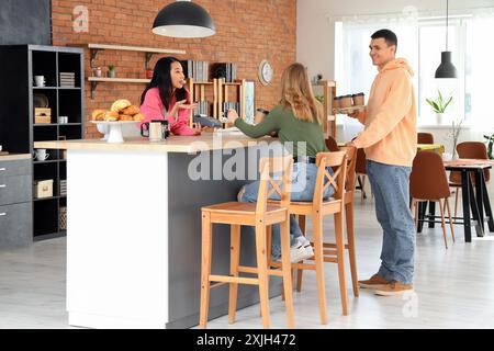 Barista asiatica che riceve il pagamento dal visitatore al bar Foto Stock