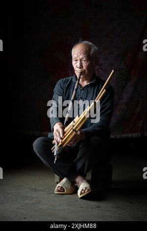 Uomo Hmong che suona il Khene, un tradizionale strumento a fiato vietnamita a Bac ha, provincia di Lao Cai, Vietnam Foto Stock