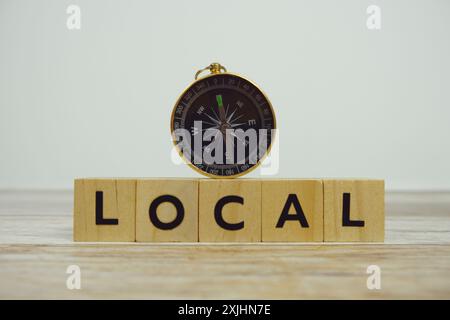 Bussola con blocchi di legno lettere alfabetiche LOCALI su fondo di legno Foto Stock