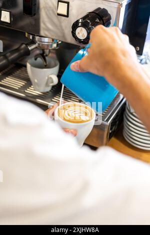 Il latte viene versato in un caffè durante il processo di preparazione. Foto Stock