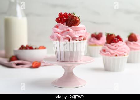 Gustosi cupcake con fragole e ribes rosso sul tavolo bianco Foto Stock