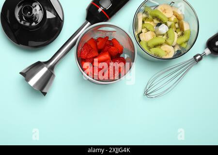 Kit frullatore a immersione, frutta fresca e fragole su sfondo turchese, piatto. Spazio per il testo Foto Stock