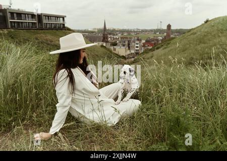 Giovane donna seduta con il papavero davanti a una vista bellissima Foto Stock