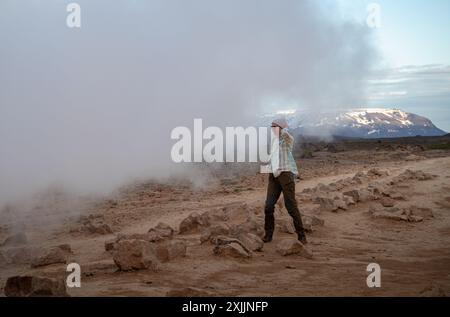 Giovane donna cammina nella zona geotermica di Myvatn, Islanda Foto Stock