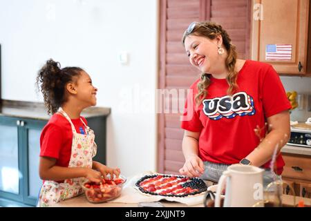 Una donna e un bambino in camicia rossa con il logo "USA", sorridenti Foto Stock