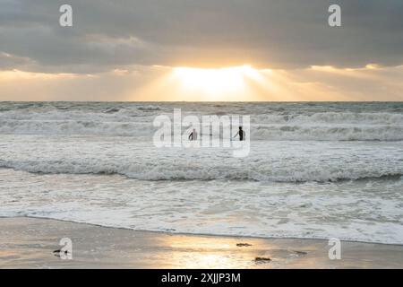 Due surfisti al tramonto in Florida, nel Golfo del Messico Foto Stock