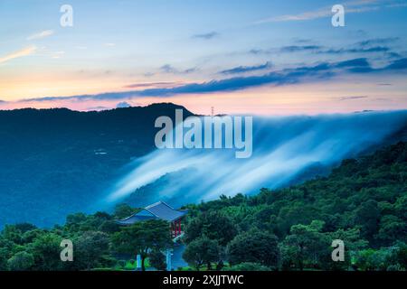 Nuvole colorate dal cielo. C'è una cascata nuvolosa sulla cima della montagna. Vista sulle montagne che circondano Emerald Reservoir. Distretto di Xindian, Tai Foto Stock