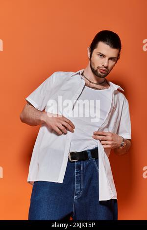 Bell'uomo caucasico vestito con camicia bianca alla moda e jeans blu. Foto Stock