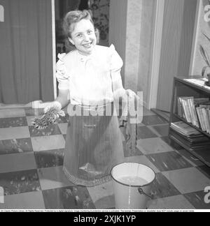 Pulire il pianale sul retro. Una giovane donna è sdraiata sul pavimento e sta strofinando per pulire il pavimento. Svezia 1952 Conard Ref 2220 Foto Stock