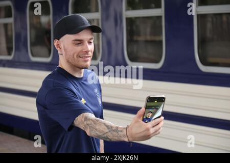 KIEV, UCRAINA - 18 LUGLIO 2024 - l'atleta Oleh Vierniaiev fa un selfie sulla piattaforma della stazione ferroviaria di Kiev-Pasazhyrskyi mentre la squadra di ginnastica artistica Ucraina parte per i Giochi Olimpici estivi di Parigi 2024, Kiev, capitale dell'Ucraina. Foto Stock