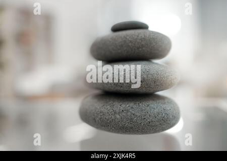 Spa, massaggi e pile di pietre calde per trattamenti di lusso, benessere e salute con atmosfera zen. Calma, bellezza e un mucchio di rocce calde in una camera vuota Foto Stock