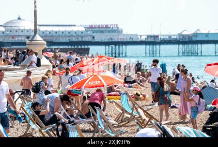 Brighton Regno Unito 19 luglio 2024 - la folla si gode il sole caldo sulla spiaggia di Brighton con temperature previste per raggiungere i 30 gradi in alcune parti del Sud-Est : Credit Simon Dack / Alamy Live News Foto Stock