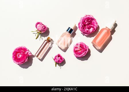 Un set di cosmetici per idratare, ringiovanire la pelle del viso e del corpo a base di oli di petalo di rosa in varie bottiglie cosmetiche. vista dall'alto Foto Stock