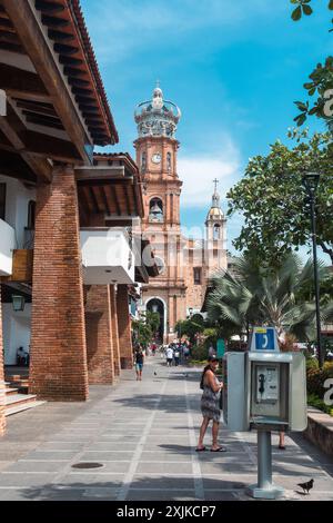 Puerto Vallarta, Messico - 27 marzo 2019: Una vivace scena di strada con la famosa torre parrocchiale. Foto Stock