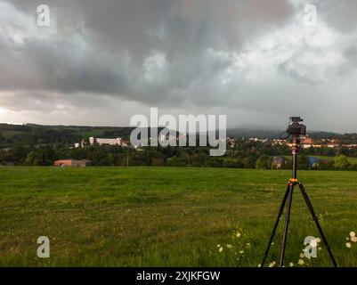 Una macchina fotografica su un treppiede in un campo che si affaccia sulla piccola città di Rochlitz in Sassonia, Germania Foto Stock