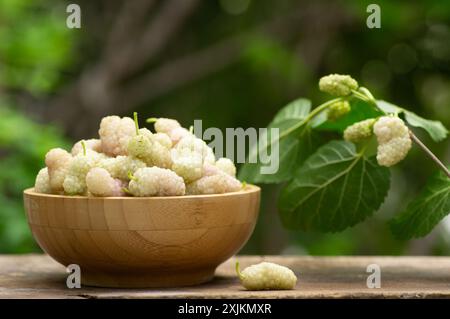 Gelsi bianchi freschi in ciotola su un tavolo in legno in giardino, frutta estiva Foto Stock